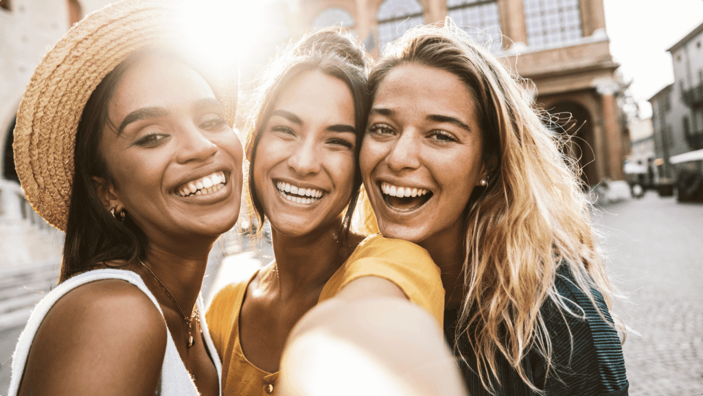 A selfie photo of three young women smiling